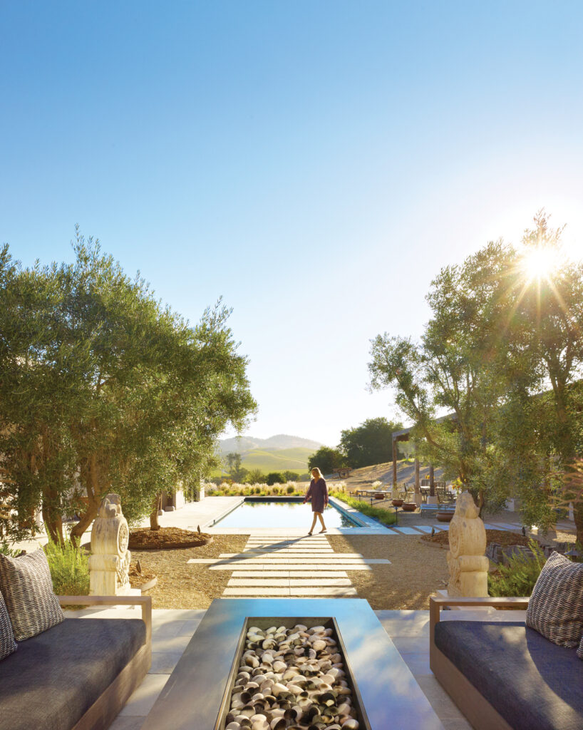 Woman walking near a pool and fire pit