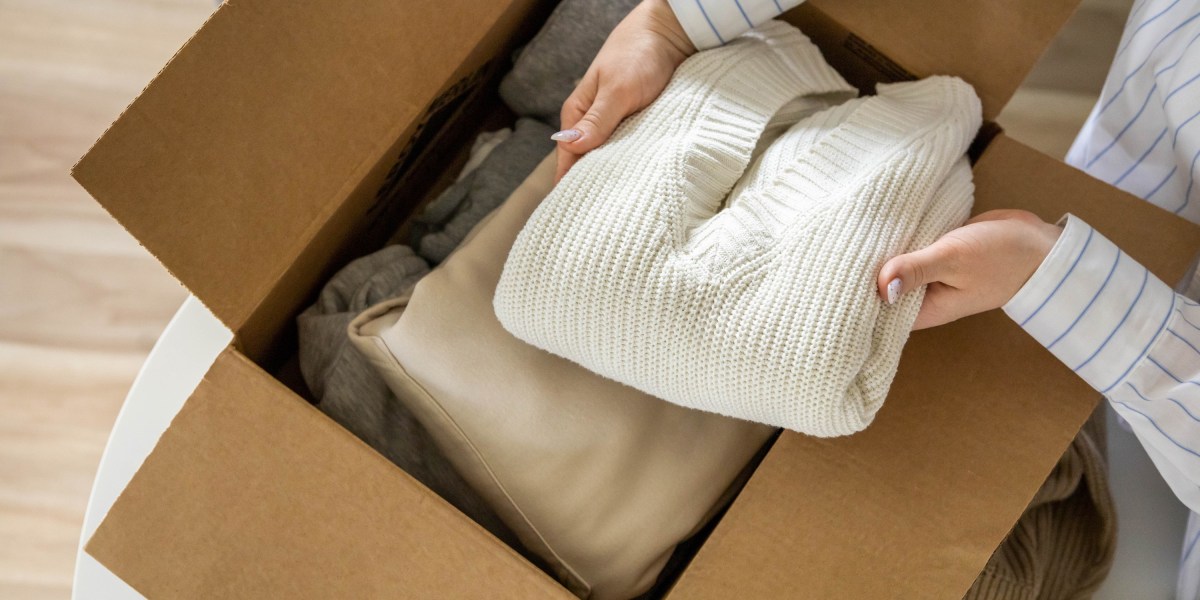 Woman putting sweater in cardboard box