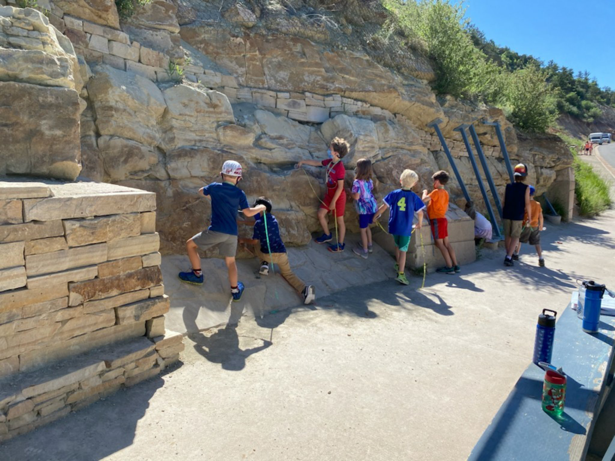 summer-campers-measure-fossil-bones-embedded-in-jurassic-rock-layers-at-dinosaur-ridge