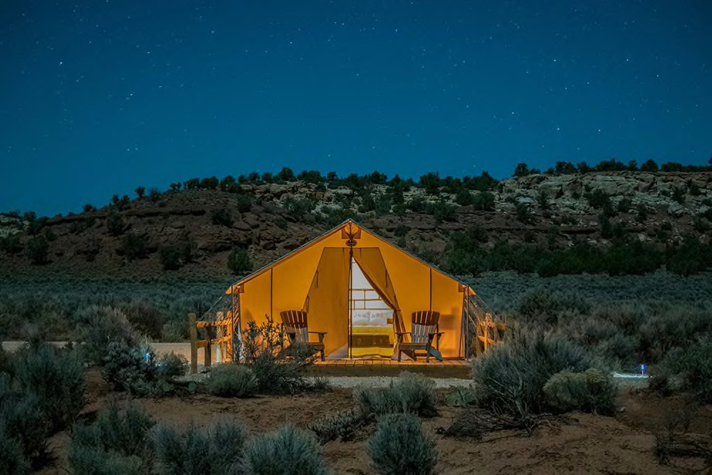 large canvas tent illuminated under the stars