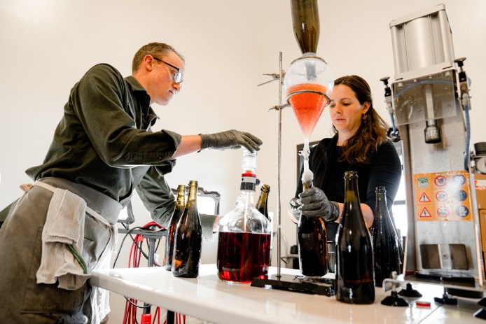 Carboniste winemakers bottling sparkling red wine