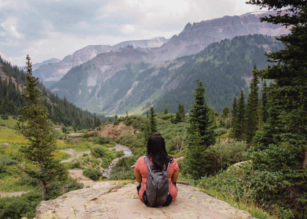hiker with backpack on boulder