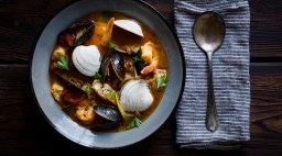 Bowl of cioppino with napkin and spoon