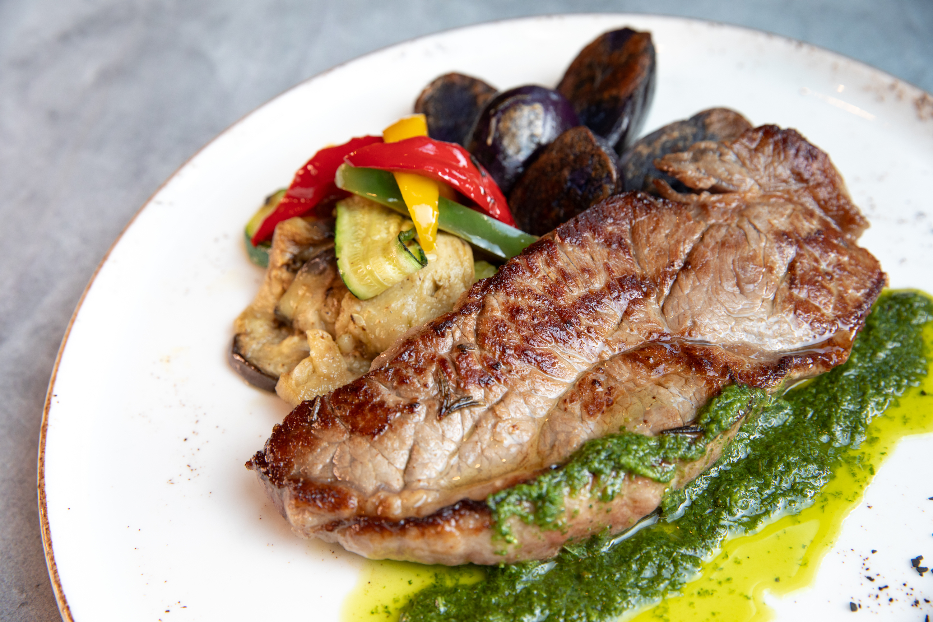 bistecca-mabistecca-black-angus-beef-roasted-purple-potatoes-grilled-vegetables-and-aromatic-herb-sauce