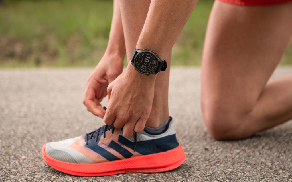 person tying shoes and displaying watch on wrist