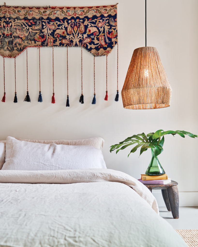 Newport Beach home bedroom with pendant light and nightstand with plant