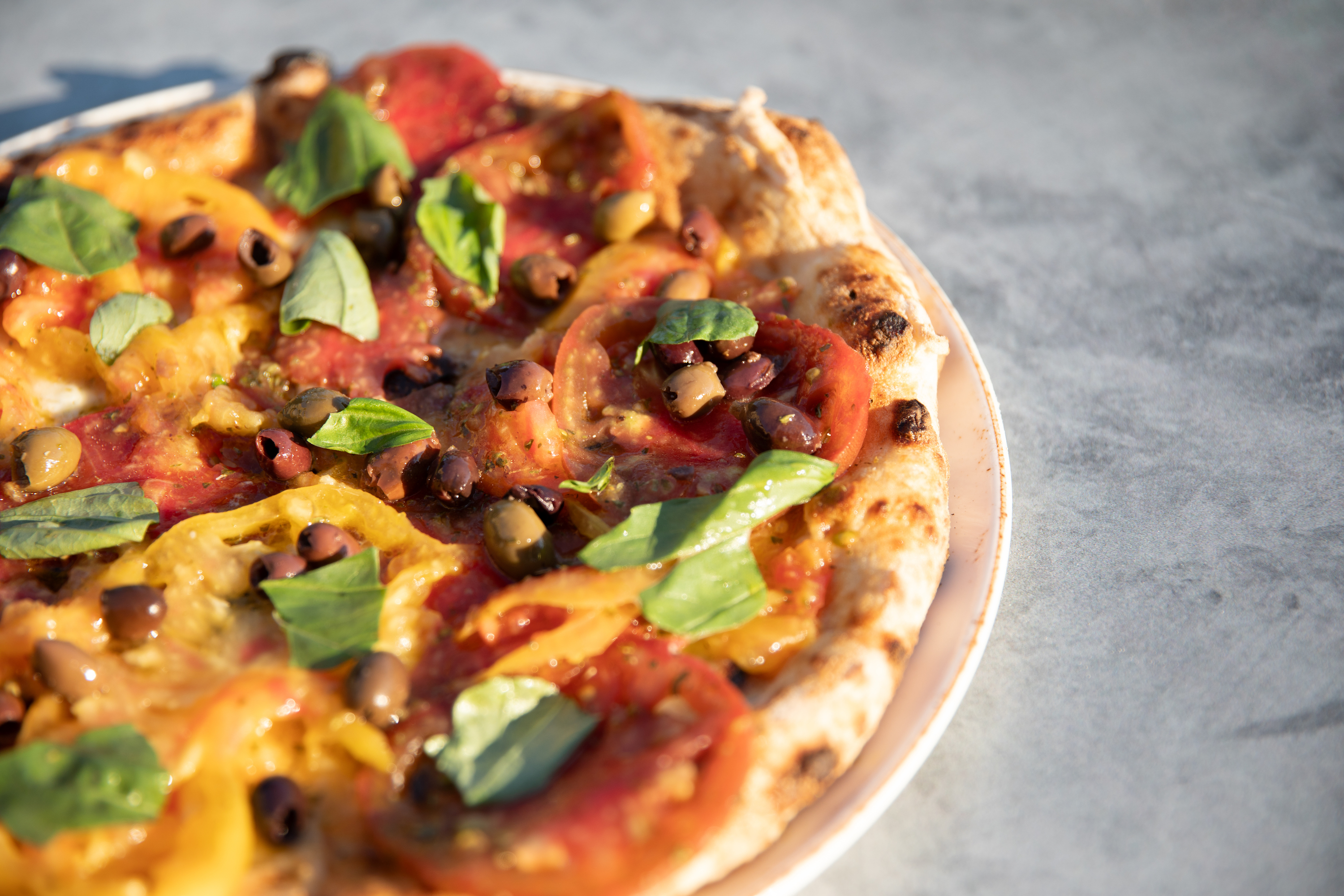 wood-fired-pizza-with-olives-tomatoes-and-basil