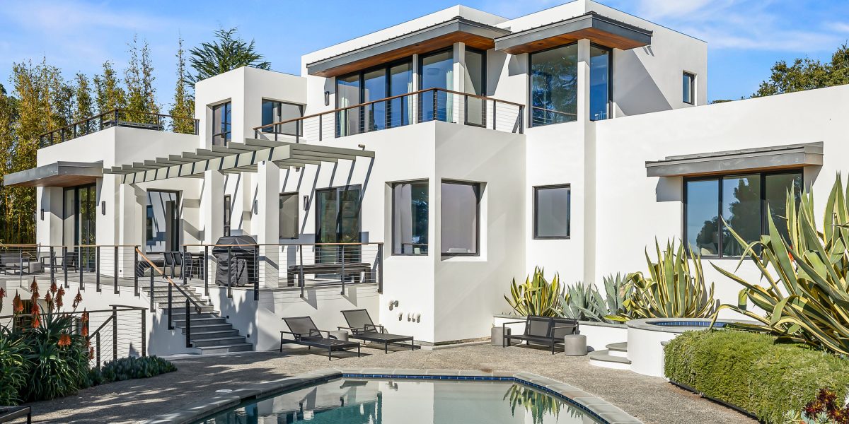 blue sky over a luxury home with a swimming pool in foreground