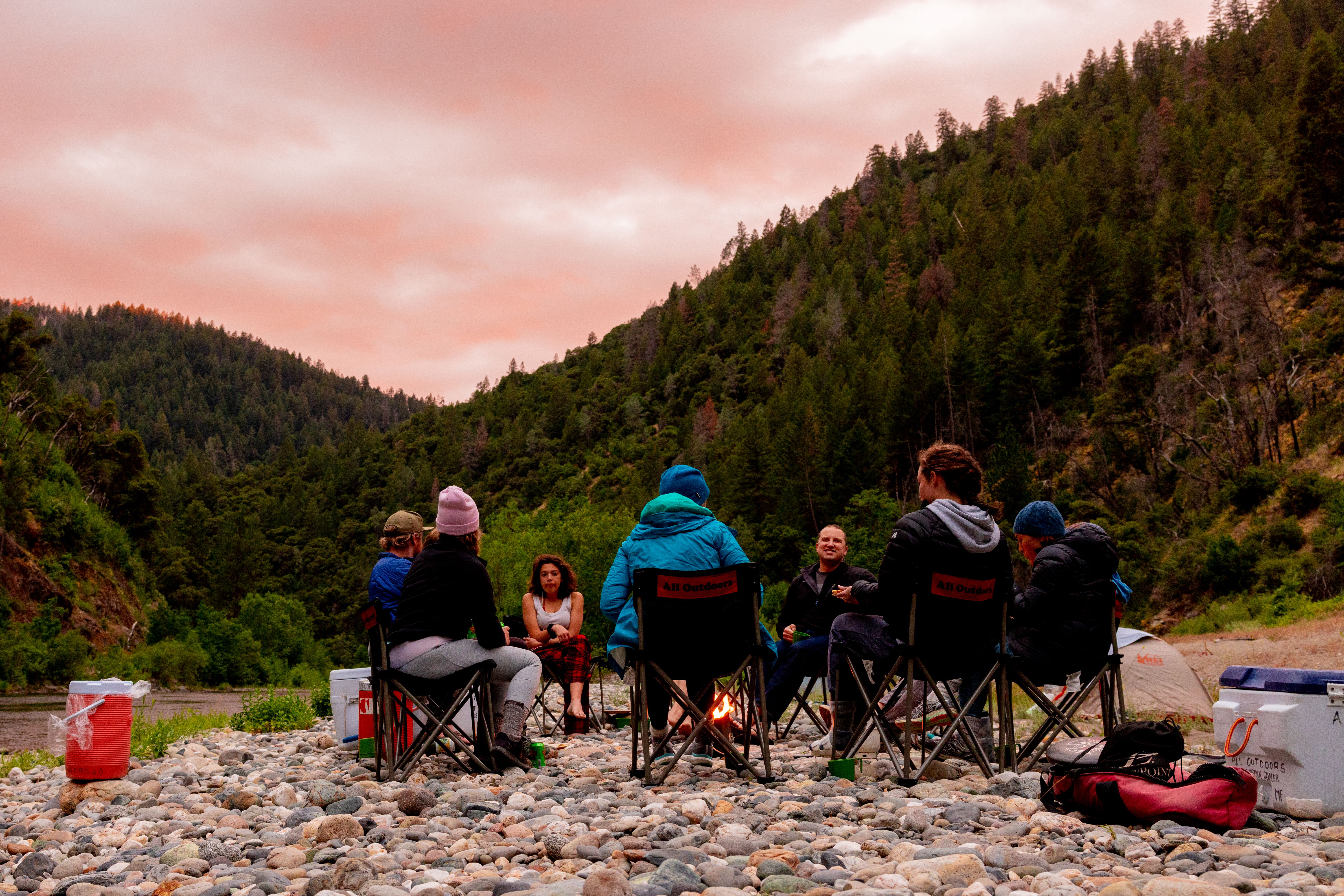 guests-relax-around-a-camp-fire-after-a-day-of-whitewater-rafting