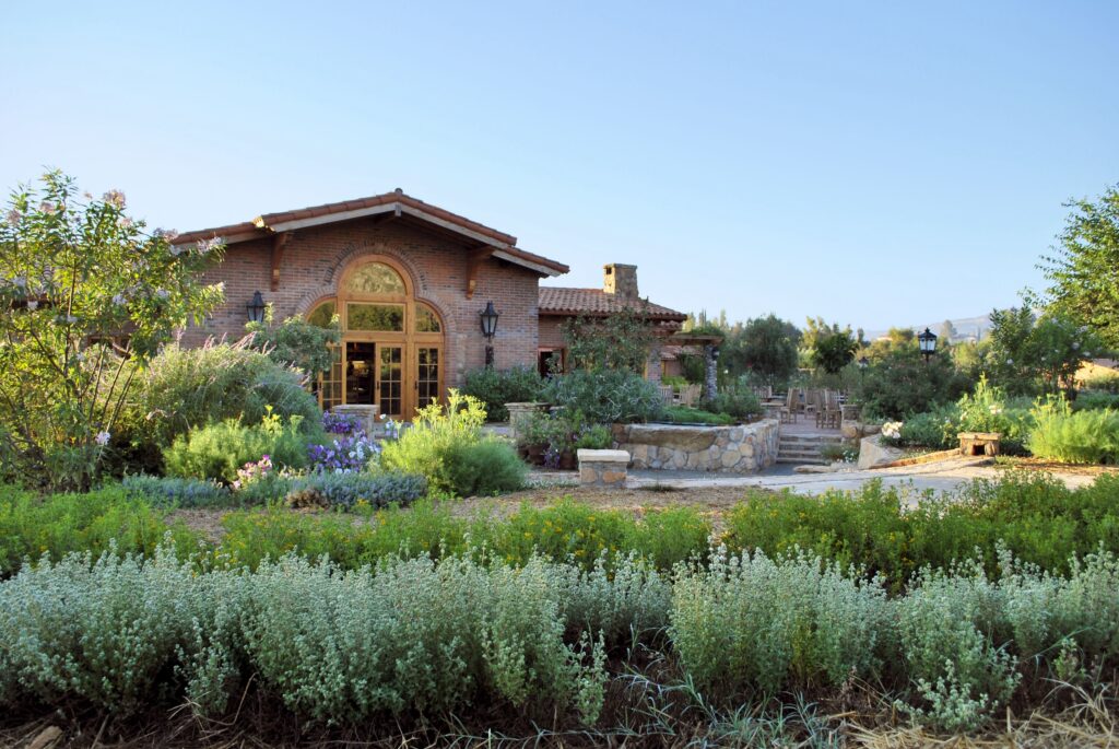The exterior of a property in the desert with greenery.