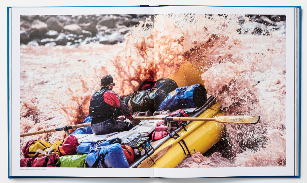 whitewater raft plows into wave that splashes over its front