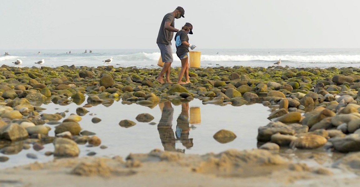 Volunteers pick up trash along the coastline in Santa Monica with Heal the Bay