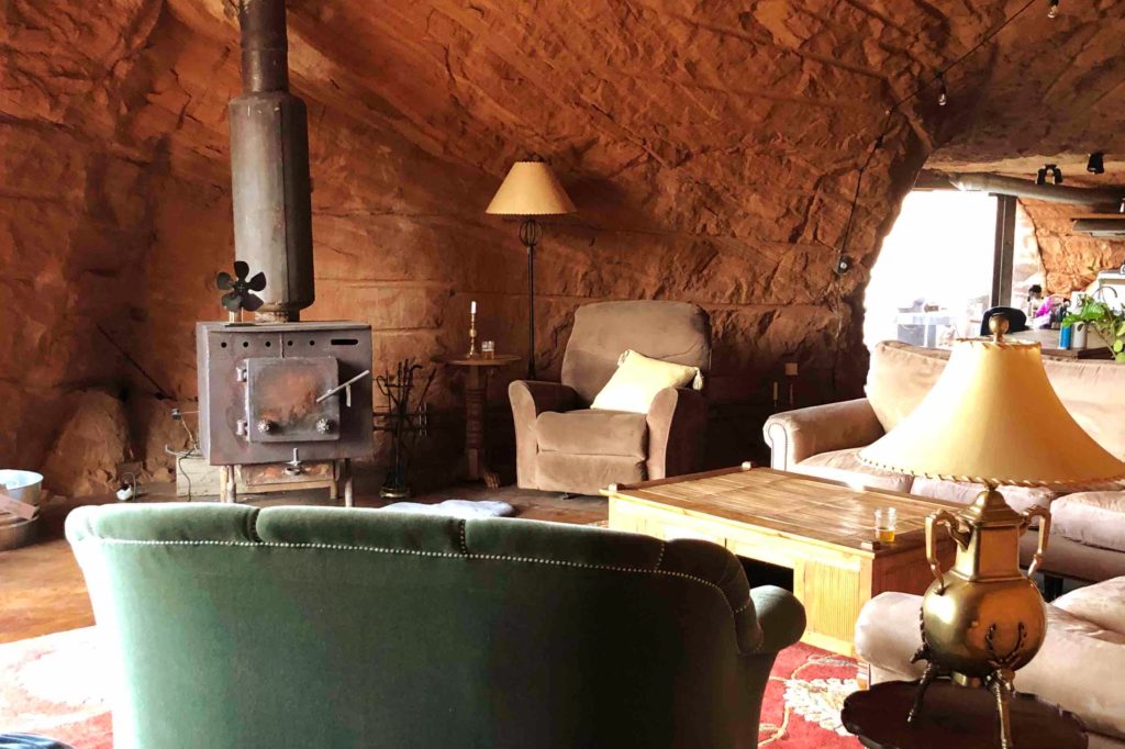 couch, chair and wood stove in living room inside cave