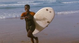 Woman on Beach with Surfboard