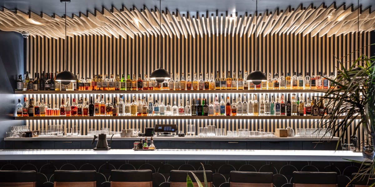 A long bar with shelves of liquor.
