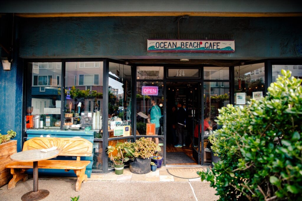 The outside of a bar featuring the sign "Ocean Beach Cafe."