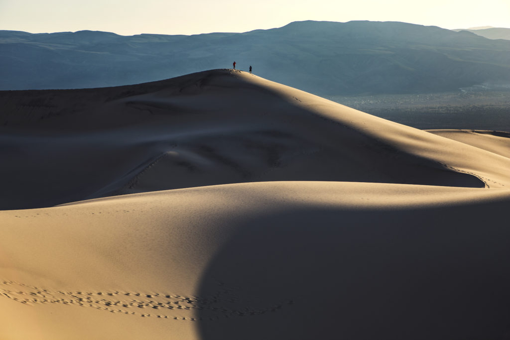 Two Hikers atop a Giant Sand Dune in Death Valley