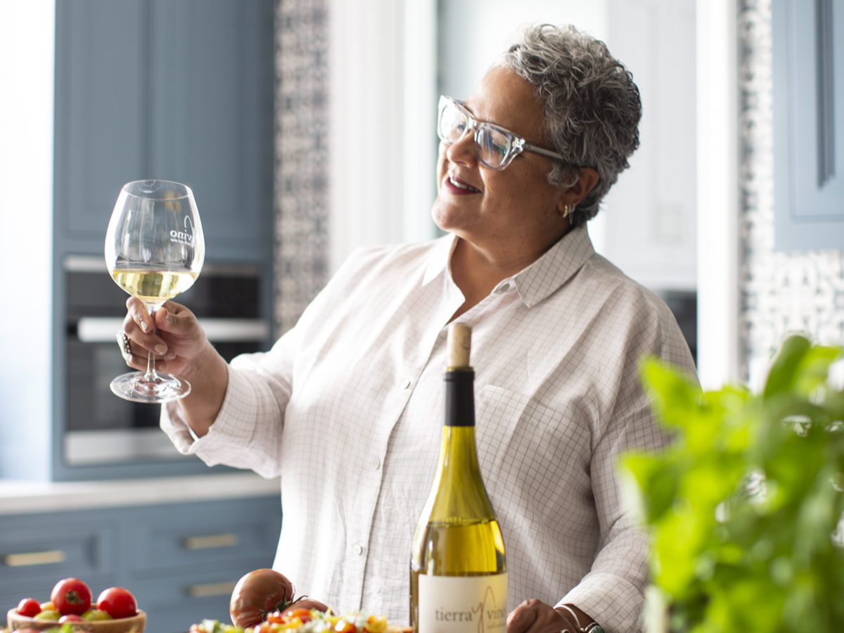 Caren Rideau Examining a Glass of White Wine