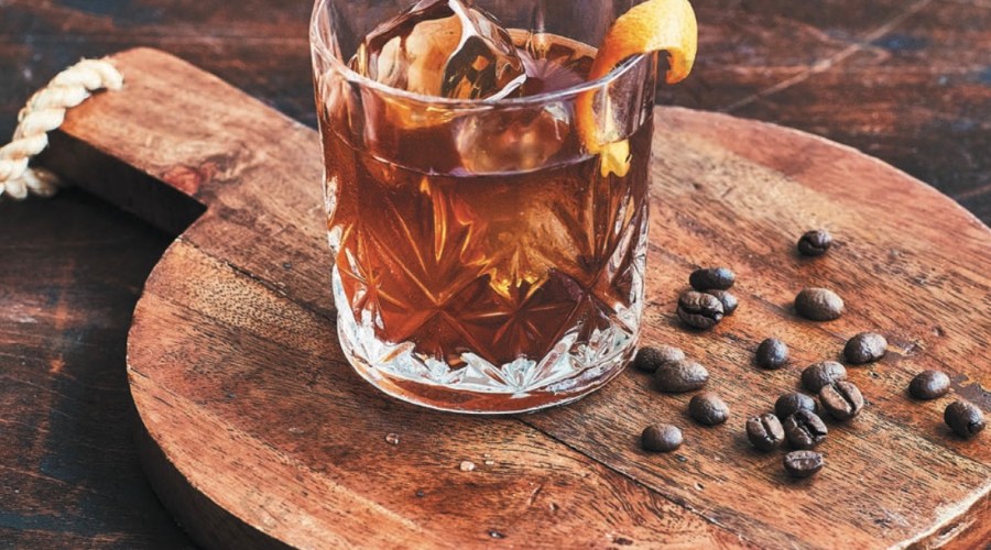 coffee old fashioned by coffee beans on wooden serving paddle