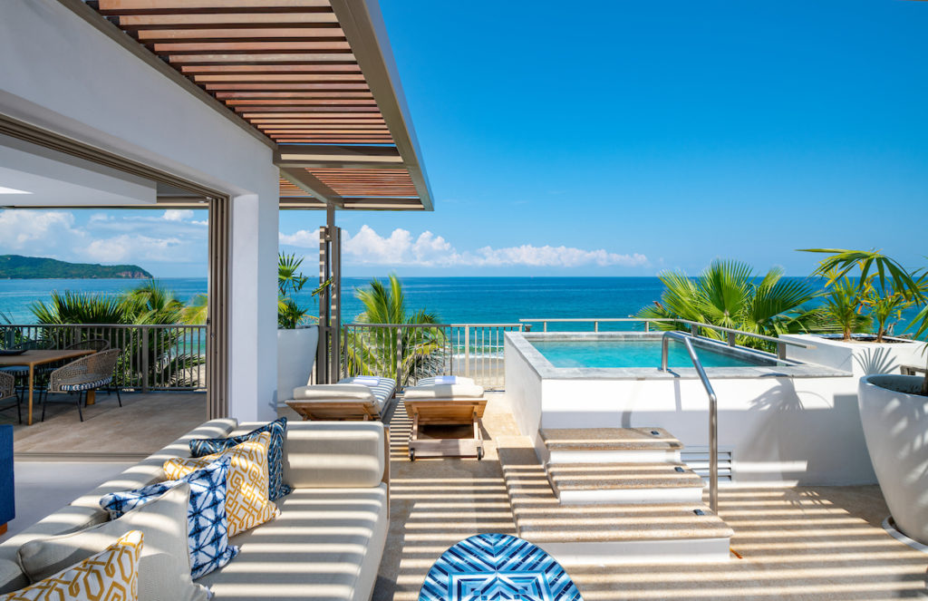 hot tub on deck overlooking ocean with palm trees