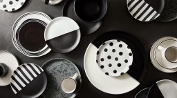 A collection of black and white dishes and mugs.