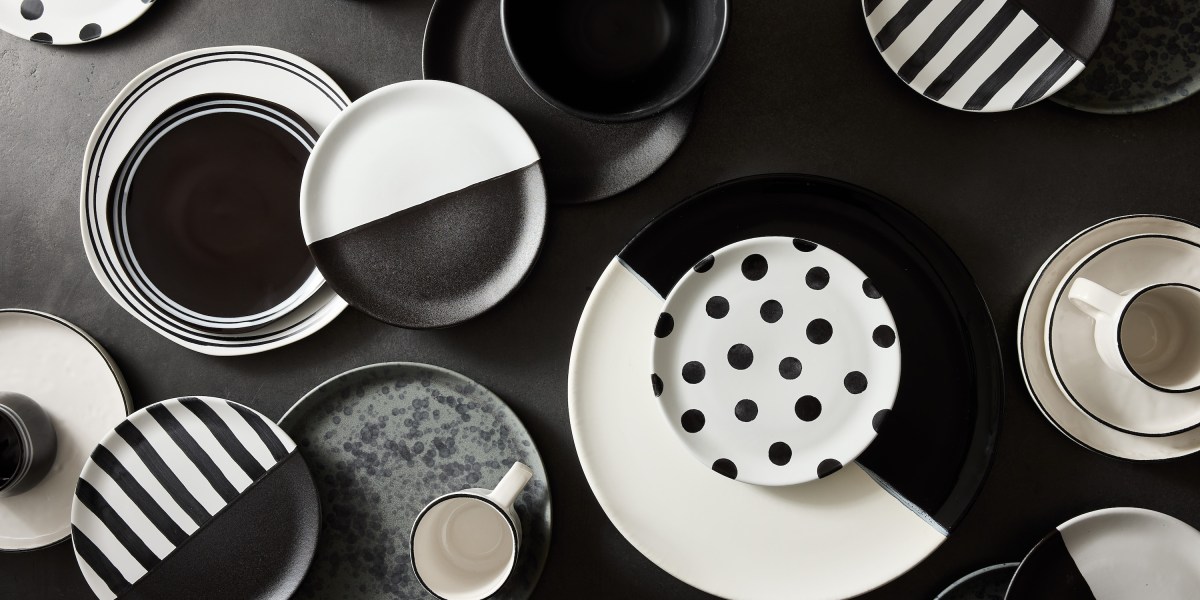 A collection of black and white dishes and mugs.