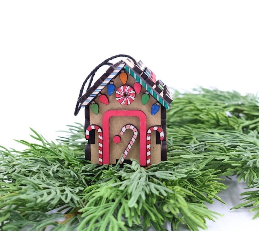 decorated gingerbread house ornament on pine sprigs