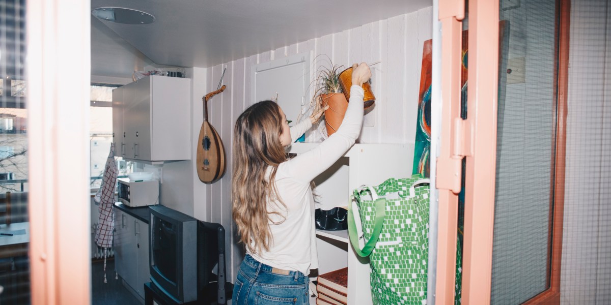 girl watering plants in room