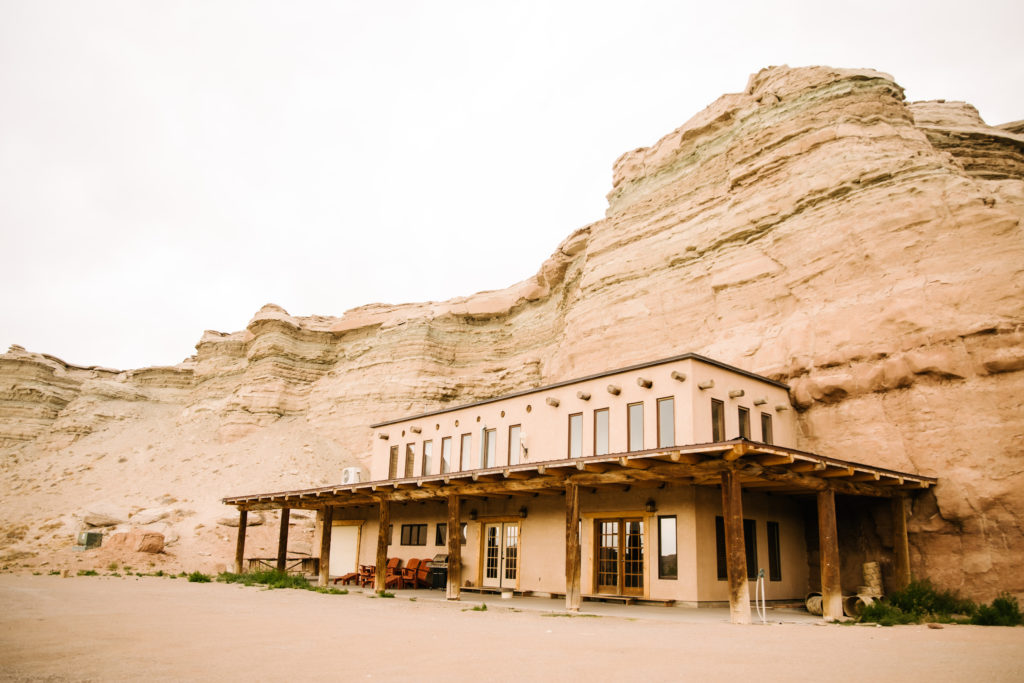 sandstone house set against rock face in desert