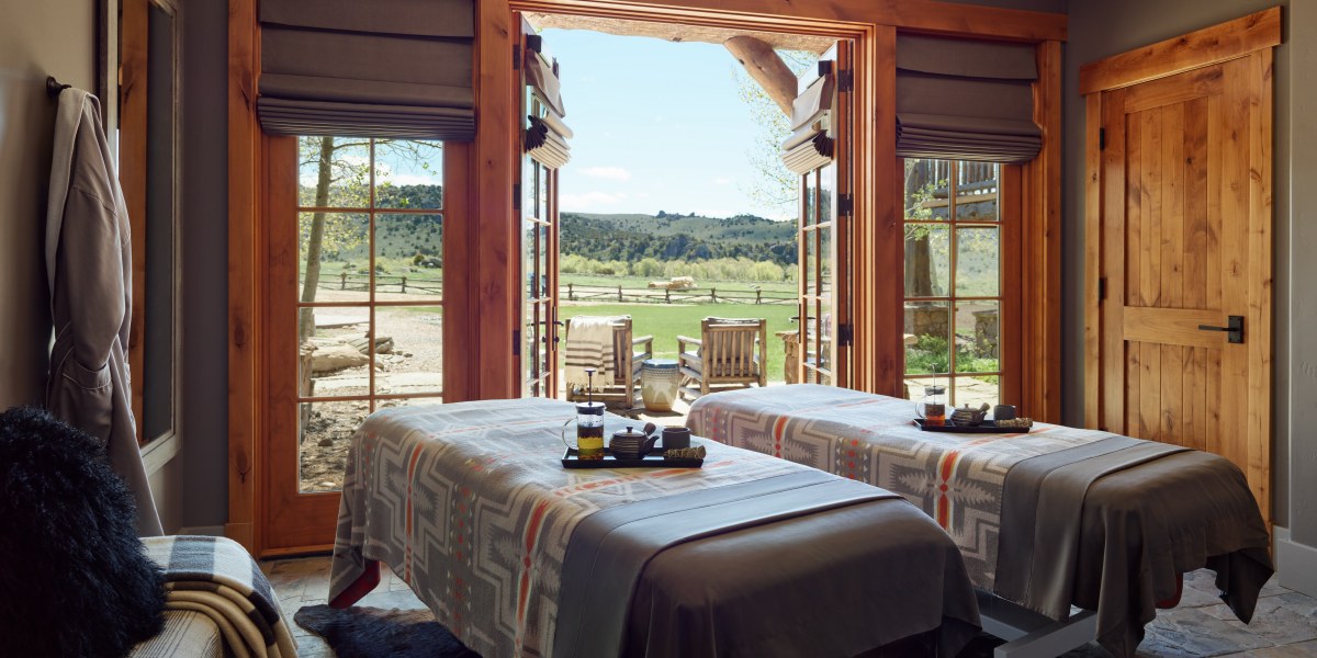 Two massage beds in a treatment room overlooking a ranch.