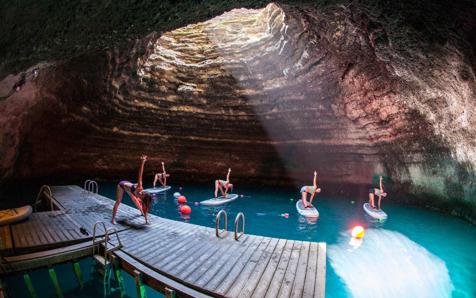 People stand-up paddle boarding in the Homestead Crater hot spring pool in Utah