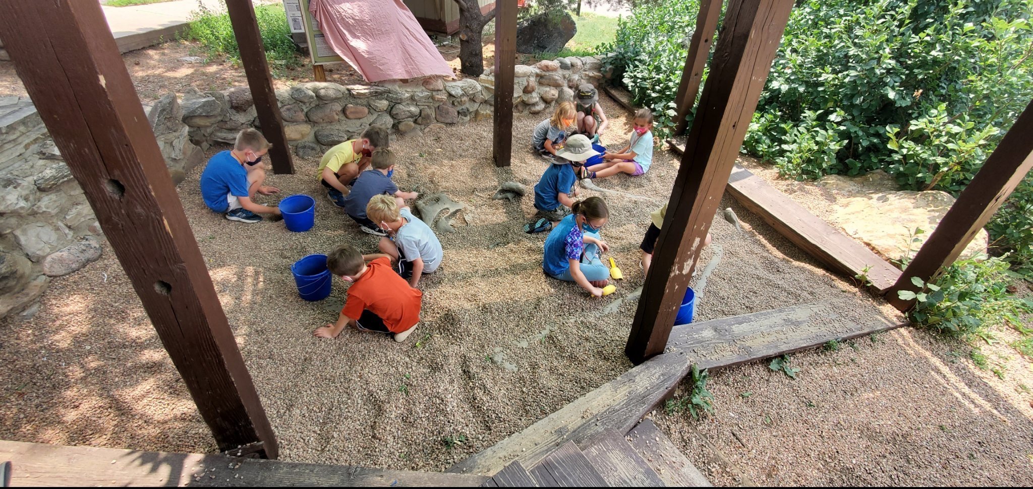 kids-enjoy-uncovering-a-dinosaur-skeleton-replica-in-a-dig-site-simulation-at-dinosaur-ridge
