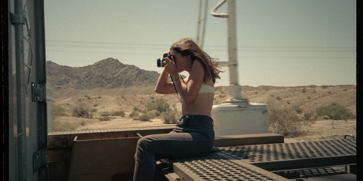 Woman taking film photo while riding train