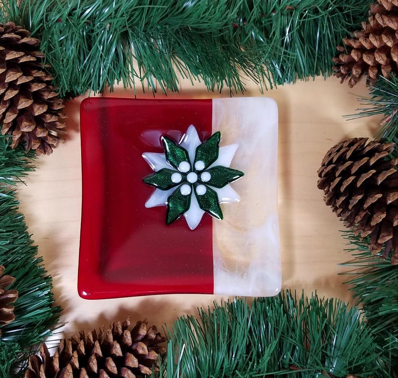 red and white glass plate with green and white flower in center