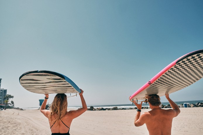 Simmons and O'Brien Carrying Surfboards