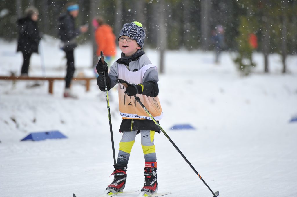 Little kid cross country skiing in snow in West Yellowstone