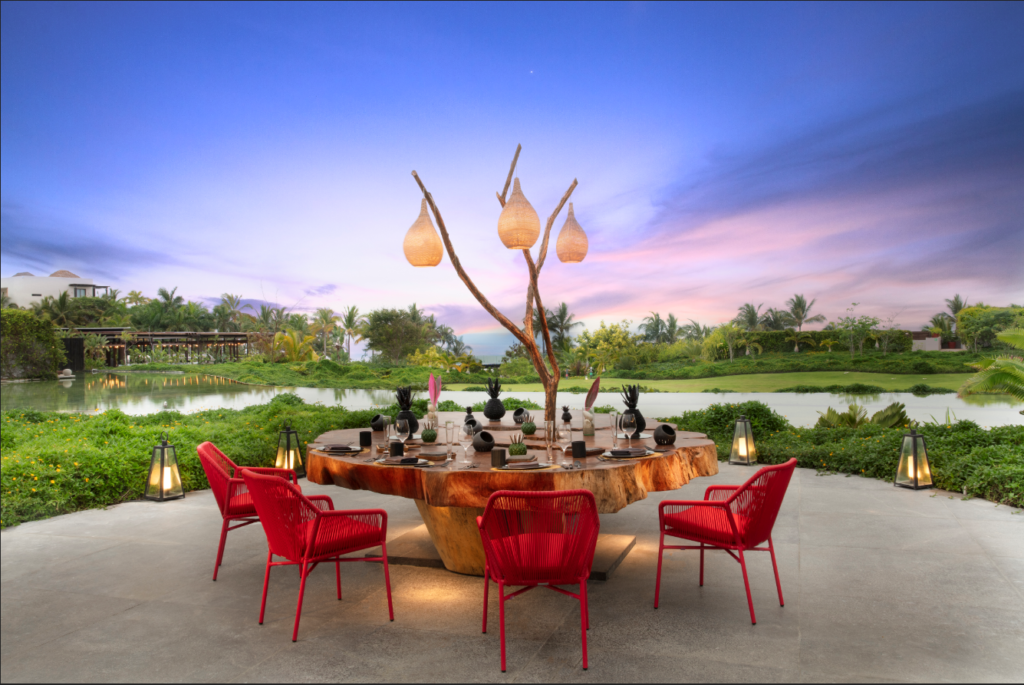 private table sits among greenery with sunset colors in sky